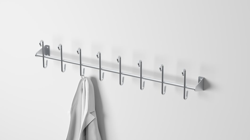 Stainless steel coat rack with 8 single pegs, ideal for organizing coats, aprons, and work gear in industrial or commercial spaces.
